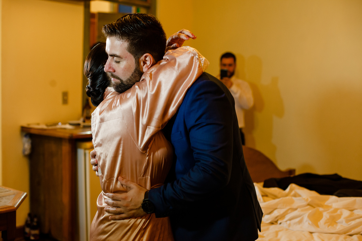 mãe do noivo abarçando forte o noivo