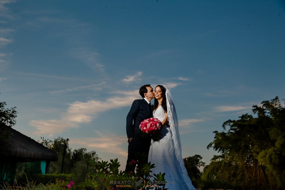 noivo beijando a noiva no por do sol