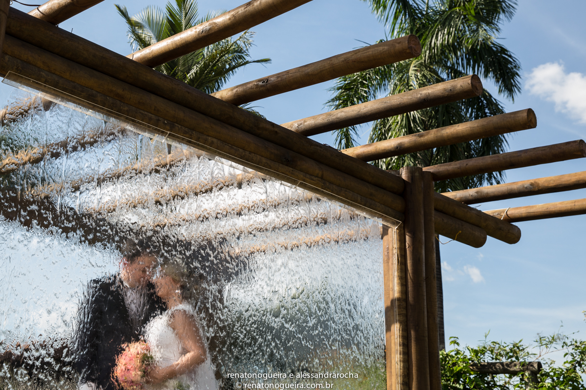 Silhueta dos noivos na agus que cai sobre o vidro