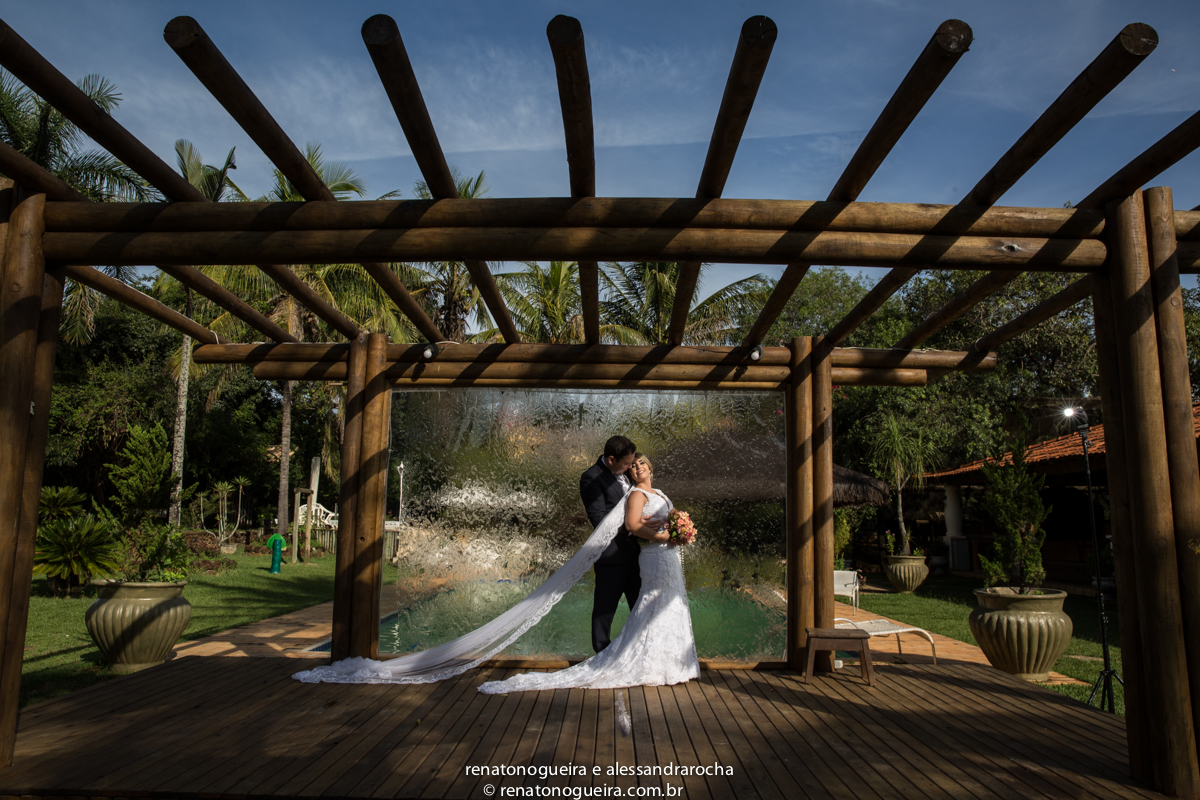 fotografia dos noivos na beira da piscina, com uma caida de agua muito bonita