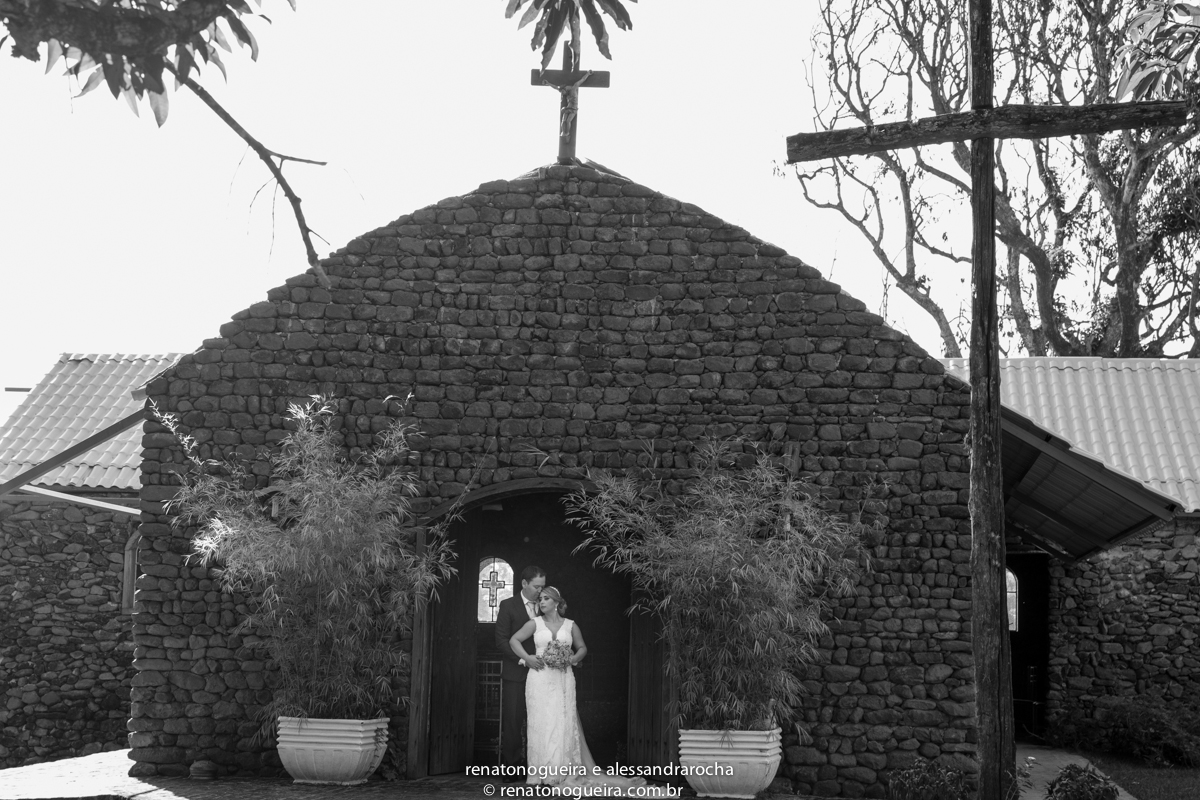casal de noivos na entrada da igreja de pedra