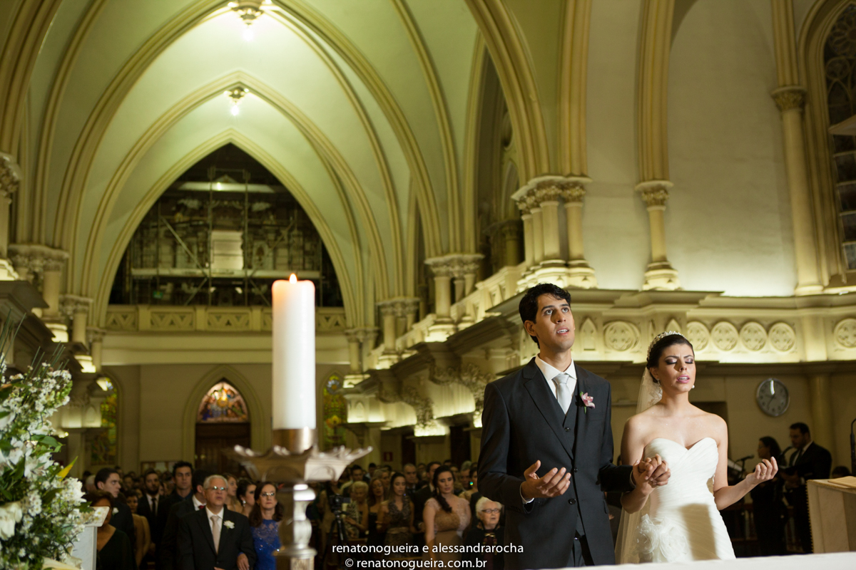 Alianças, colocação de aliança, noivo, noiva, pajem, porta alianças, igreja, Basílica de Lourdes BH, padre, vestido de noiva, terno do noivo, convidados.