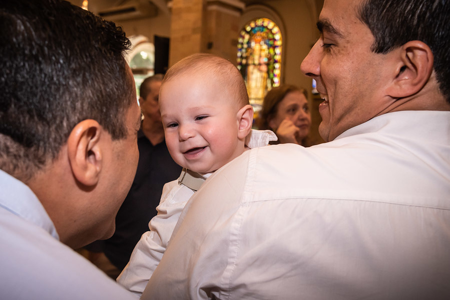 Antonio no colo do pai, rindo para o padrinho - FOTOGRAFIA DE BATIZADO - PARÓQUIA NOSSA SENHORA APARECIDA DE MOEMA - FOTÓGRAFO DE BATIZADO EM SÃO PAULO - RODRIGO MARTIN FOTOGRAFIA