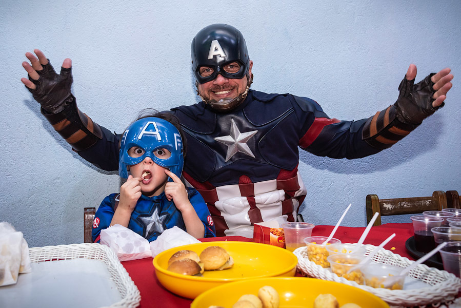Arthur comendo vestido de Capitão América do lado do real - FOTOGRAFIA DE ANIVERSÁRIO - FOTÓGRAFO DE ANIVERSÁRIO EM SÃO PAULO - BUFFET ESPAÇO LÁ VEM O SOL - FOTÓGRAFO PROFISSIONAL EM SÃO PAULO - ANIVERSÁRIO DO ARTHUR - RODRIGO MARTIN FOTOGRAFIA