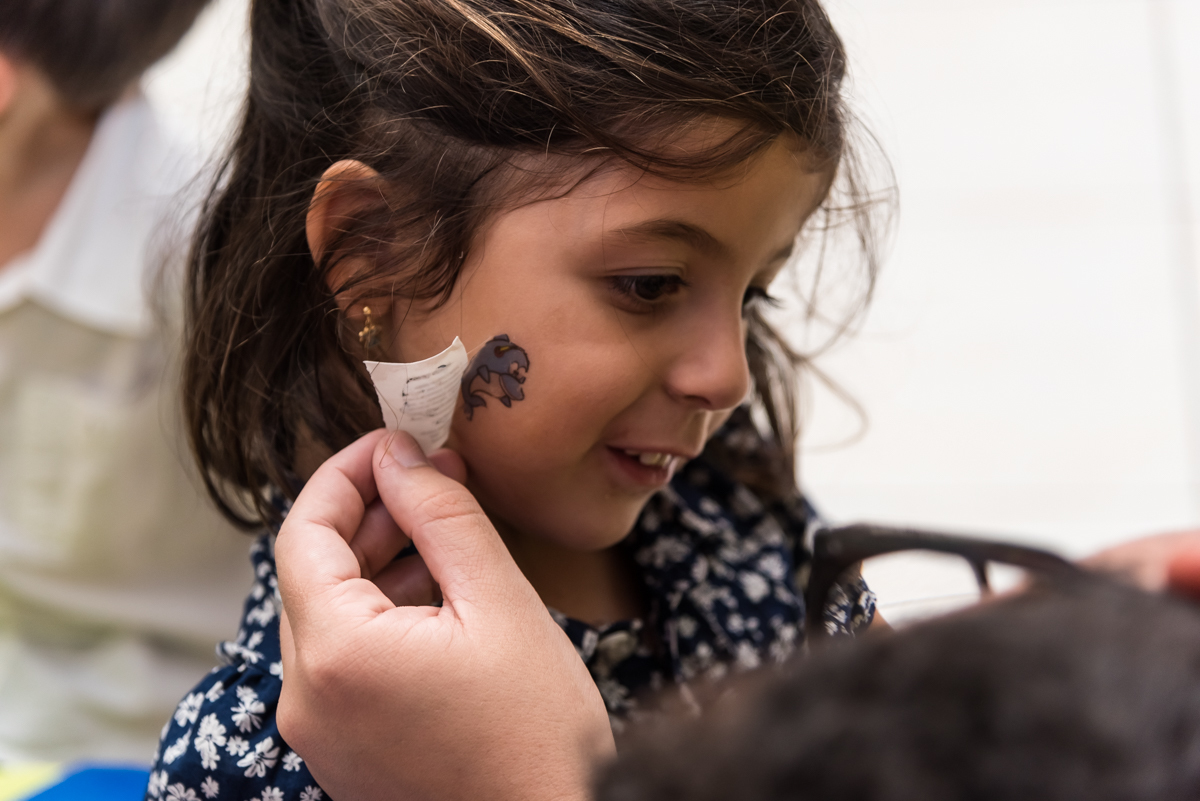 amiguinha fazendo tatuagem na bochecha pelos monitores do BUFFET CRAZY4FUN no ANIVERSÁRIO do BRUNINHO