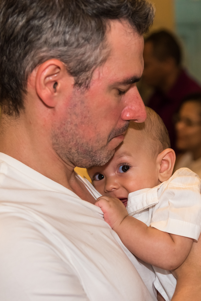 Lorenzo olhando para a câmera no colo do Padrinho em seu BATIZADO EM SANTOS NA IGREJA DO VALONGO