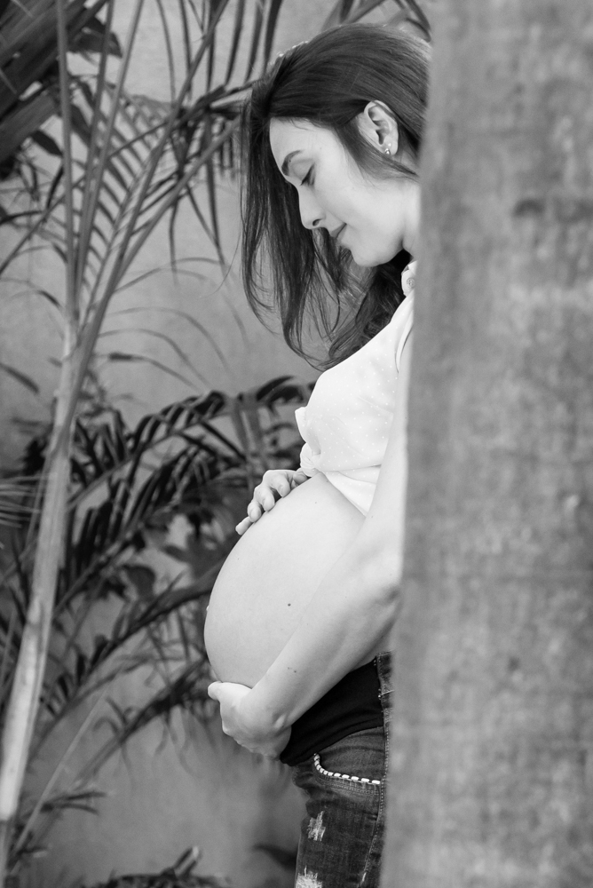 Foto em preto e branco da Mariana atrás de uma árvore no ENSAIO GESTANTE EM SÃO PAULO