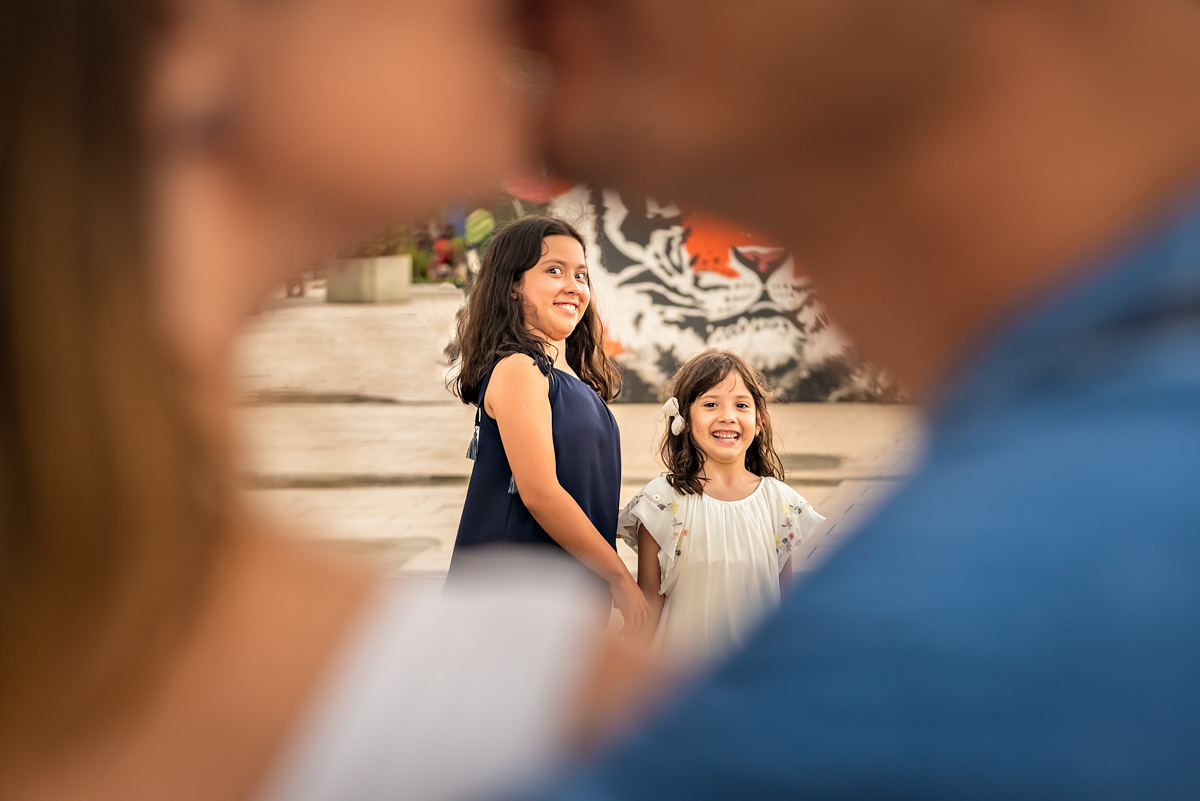 Ronaldo e Ana se beijando e Lívia e Maria com cara de Nojinho - ENSAIO FAMÍLIA EM SANTOS - ORQUIDÁRIO DE SANTOS - EMISSÁRIO SUBMARINO DE SANTOS - FAMÍLIA MISUMOTO - RODRIGO MARTIN FOTOGRAFIA