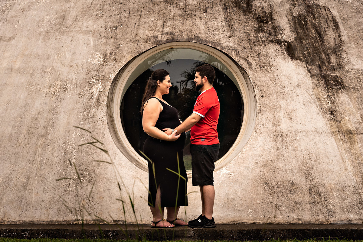 Os papais da Rafaela em frente de uma das janelas da Oca do Parque Ibirapuera - ENSAIO GESTANTE EM SÃO PAULO - FOTOGRAFIA DE GESTANTE - FOTÓGRAFO DE GESTANTE EM SÃO PAULO - PARQUE IBIRAPUERA -  ESPERANDO RAFAELA - RODRIGO MARTIN FOTOGRAFIA
