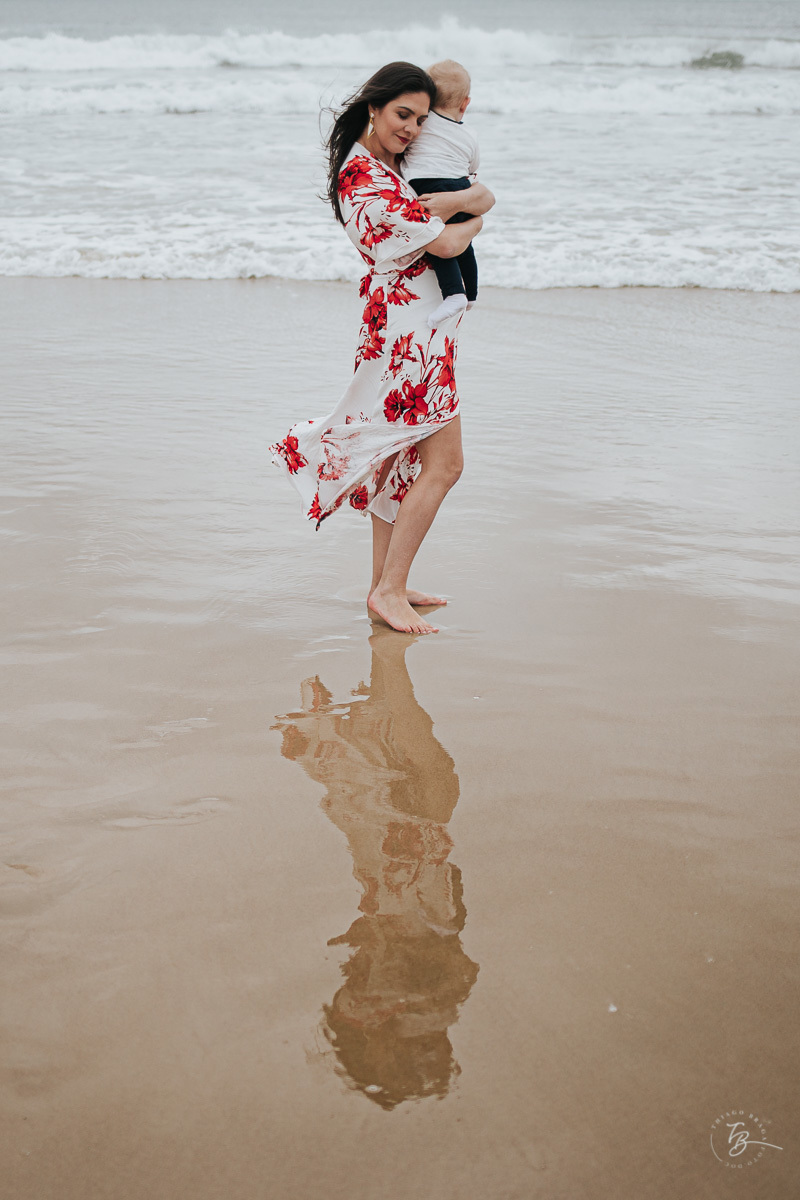 Mãe agarradinha com seu filho, próximo do mar da praia da barra da lagoa em Florianópolis.