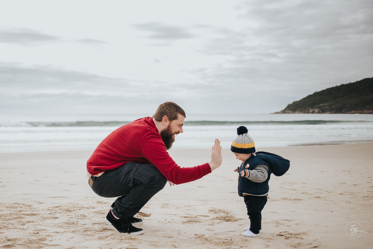 pai e filho se divertindo na praia, em ensaio de fotos de familia