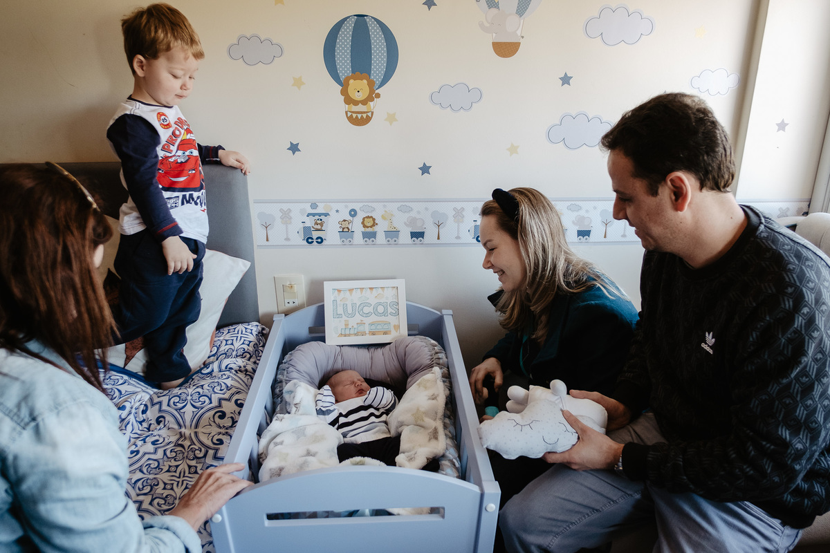 Todo mundo admirando o Lucas, quando chegou em casa. Parto normal, na maternidade Santa Helena em Florianópolis, por Thiago Braga fotografia. 