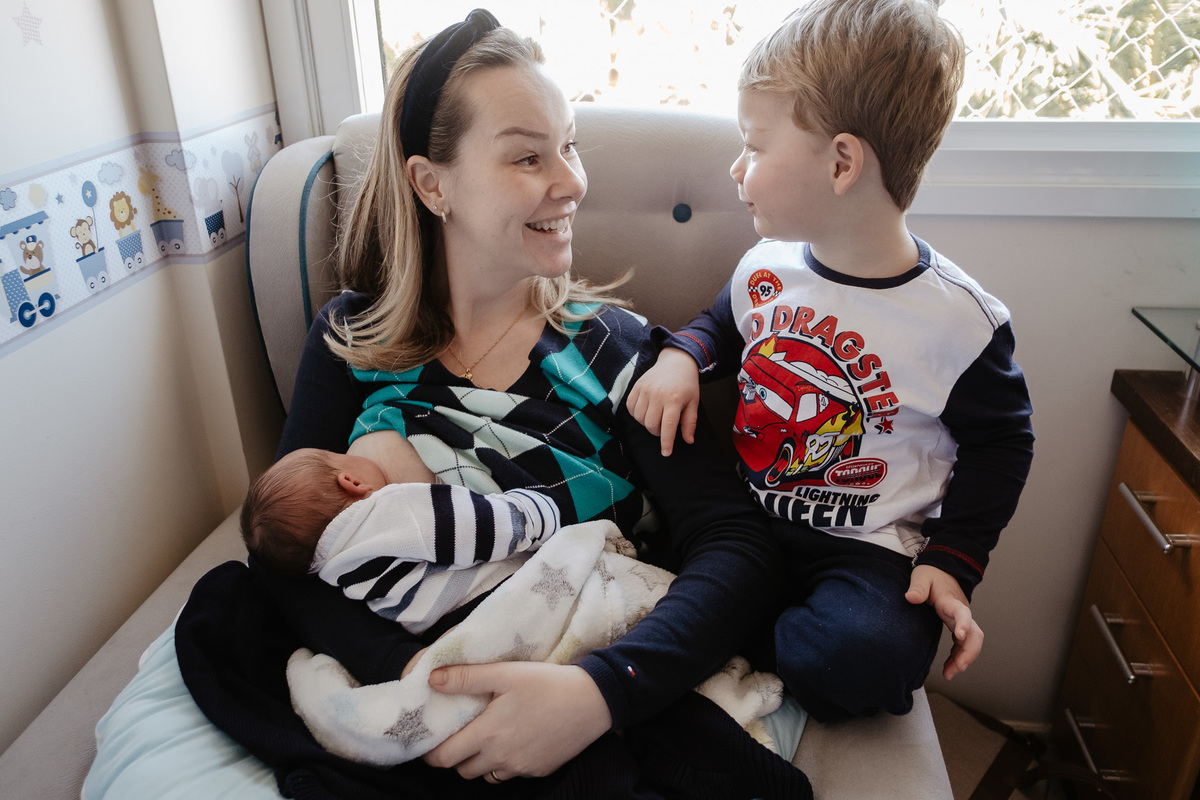 mamãe com seus dois filhos, em casa. Parto normal, na maternidade Santa Helena em Florianópolis, por Thiago Braga fotografia. 