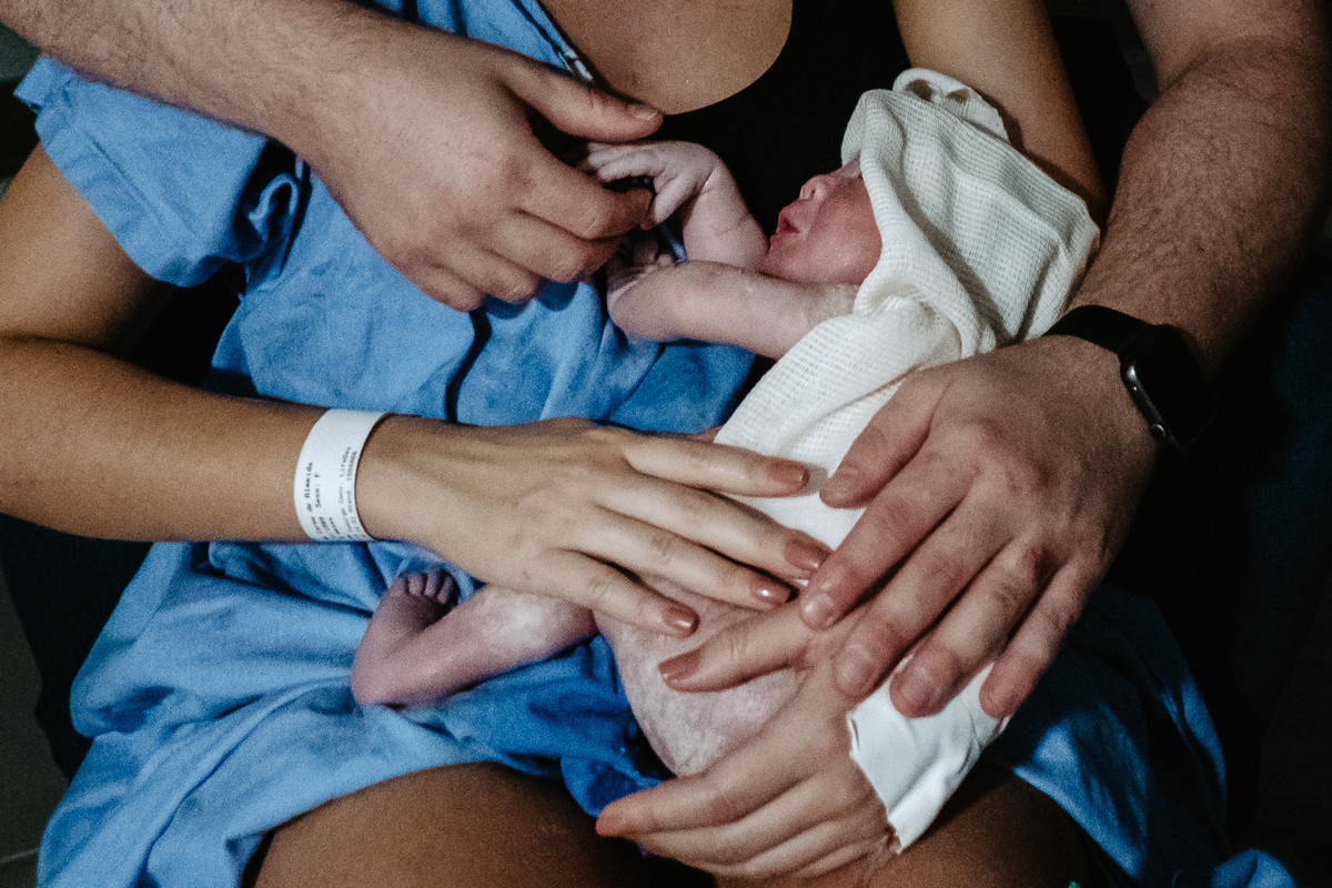 Nos braços dos pais. Fotografia de parto normal na maternidade Sata Helena em Florianópolis por Thiago Braga.