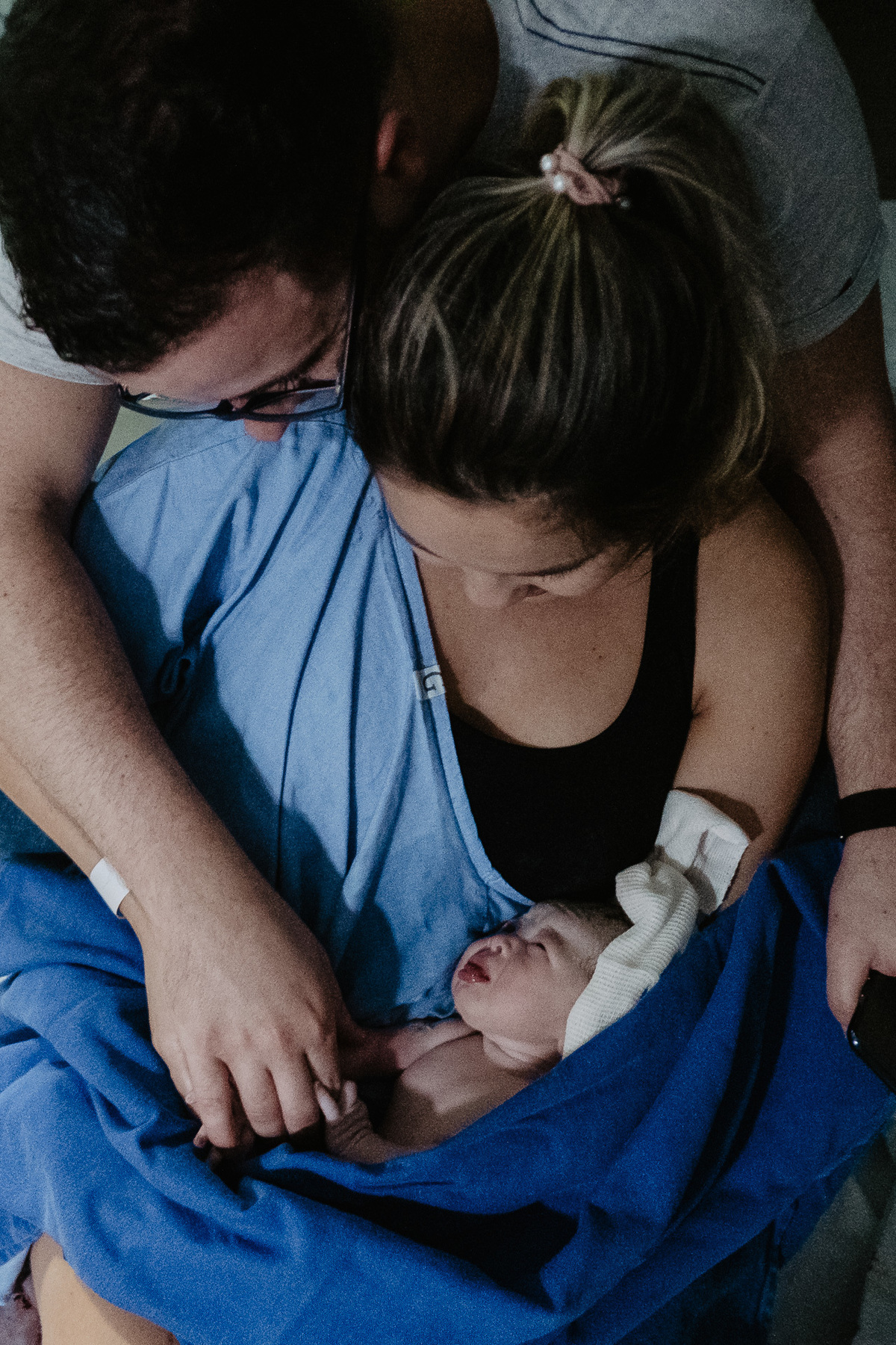 olhar entre a pequena Helena e os papais. Fotografia de parto normal na maternidade Sata Helena em Florianópolis por Thiago Braga.