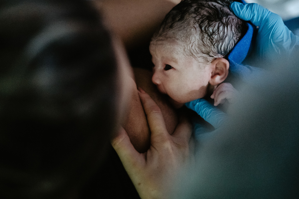 Olhares da primeira amamentação. Fotografia de parto normal na maternidade Sata Helena em Florianópolis por Thiago Braga.