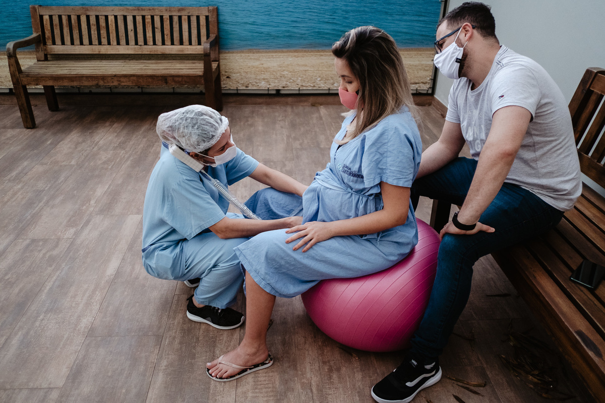 Trabalho de parto assistido. Fotografia de parto normal na maternidade Sata Helena em Florianópolis por Thiago Braga.