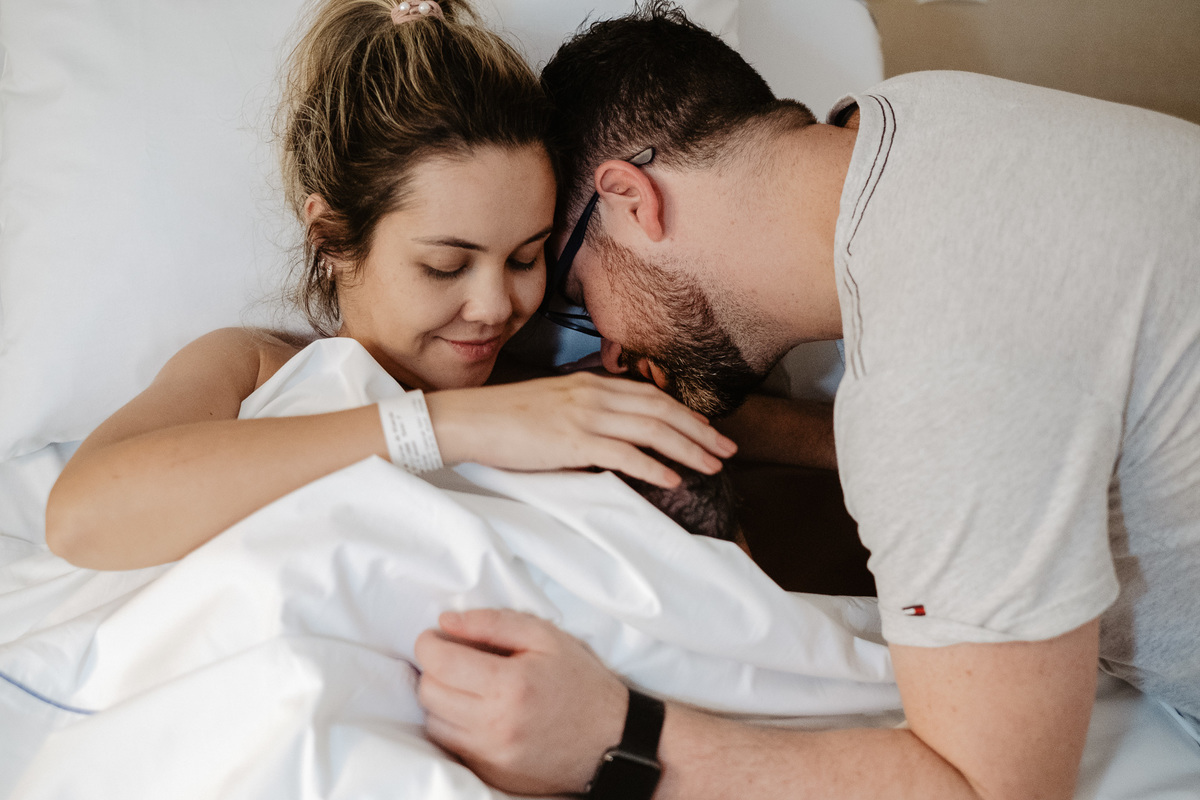 Beijo e carinho na bebê recém nascida. Fotografia de parto normal na maternidade Sata Helena em Florianópolis por Thiago Braga.