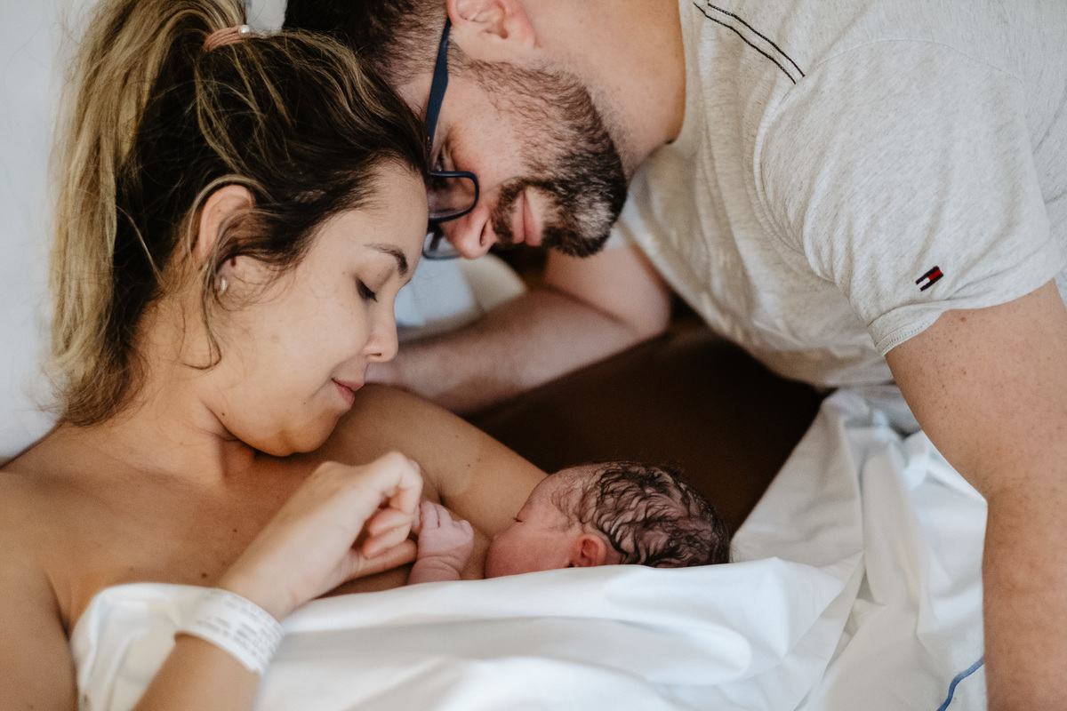 Carinho de papai e mamãe. Fotografia de parto normal na maternidade Sata Helena em Florianópolis por Thiago Braga.