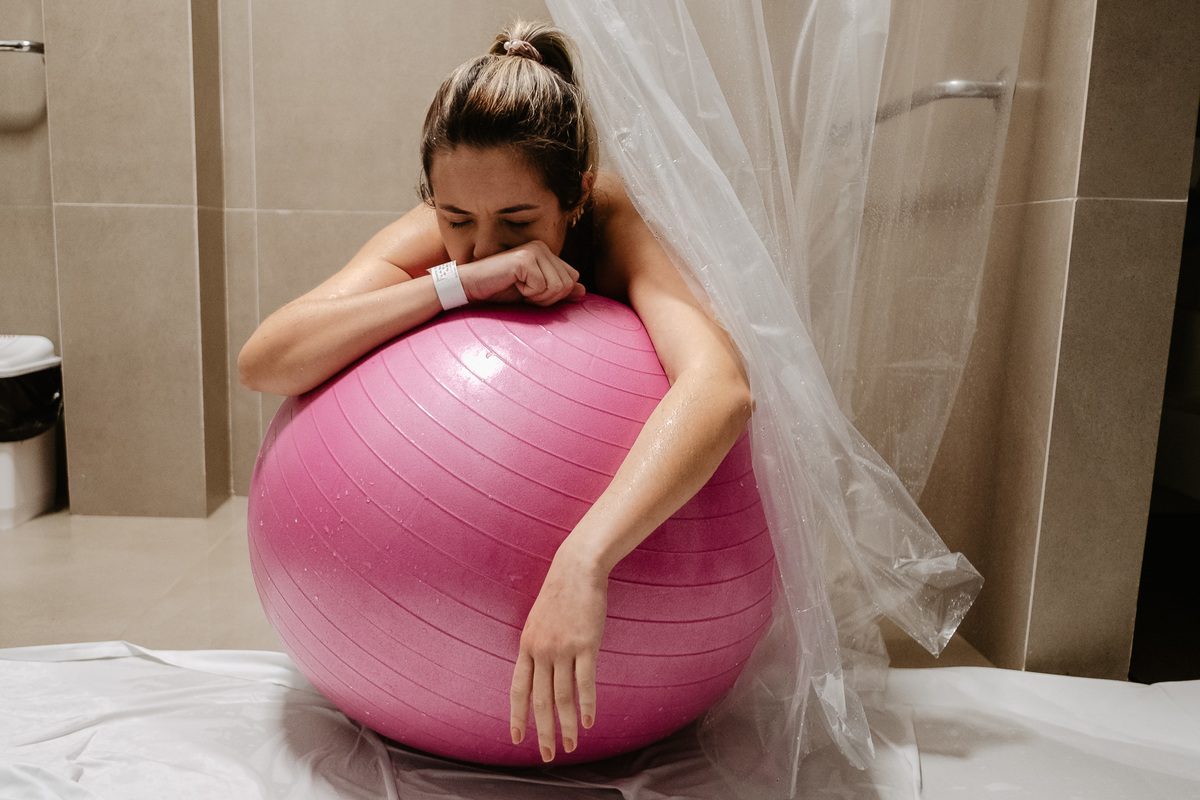Trabalho de parto com uso de bola. Fotografia de parto normal na maternidade Sata Helena em Florianópolis por Thiago Braga.