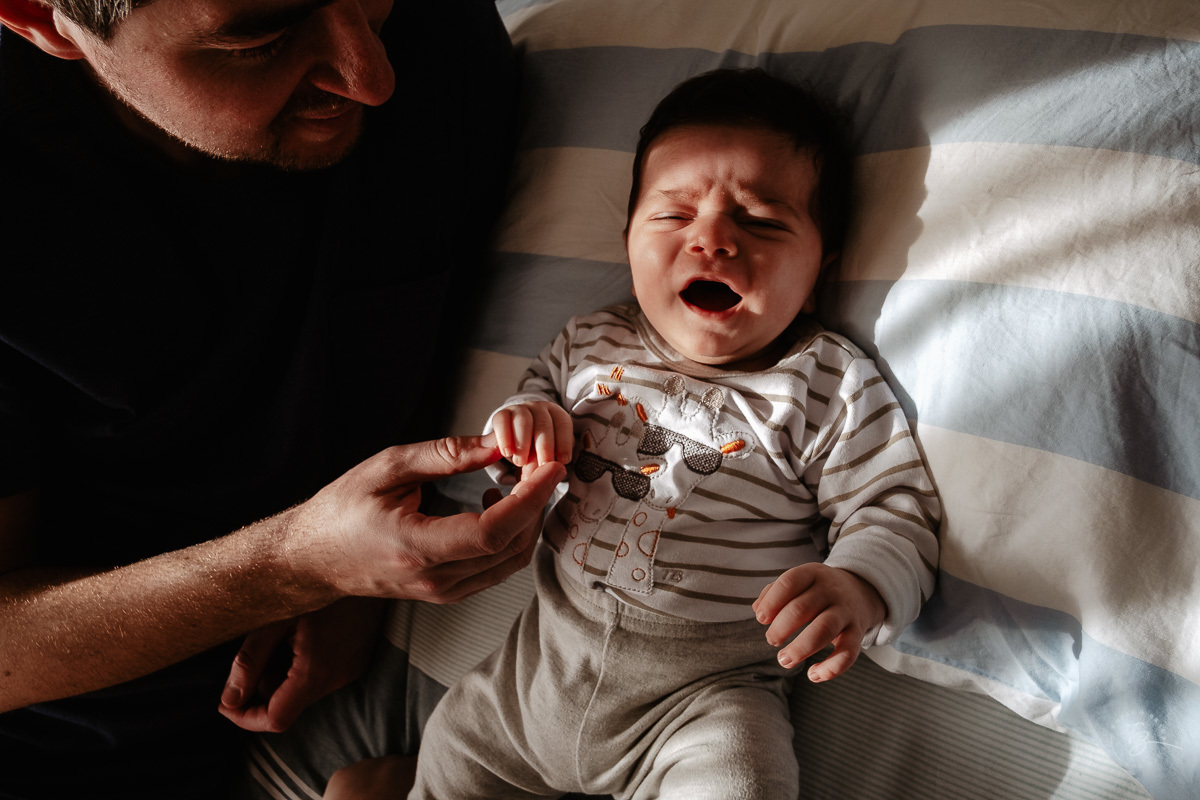 Papai e filho na cama, primeiros dias em casa. Parto documental. A chegada do Gabriel. Maternidade Santa Helena. Florianópolis/SC. Por Thiago Braga fotografia. 