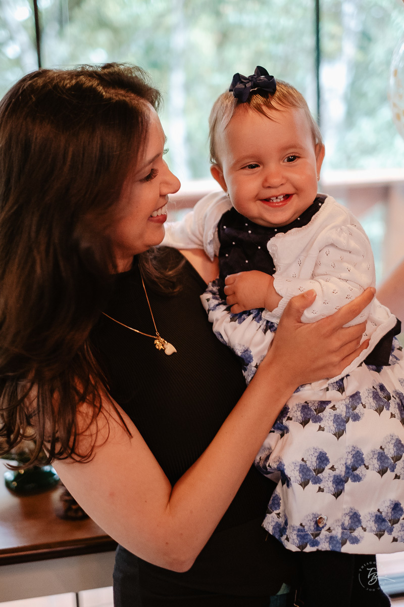 Bebê sorrindo com mamãe. Fotografia documental de aniversário em Rancho Queimado - SC por Thiago Braga fotografia. Fotografia de aniversário infantil.