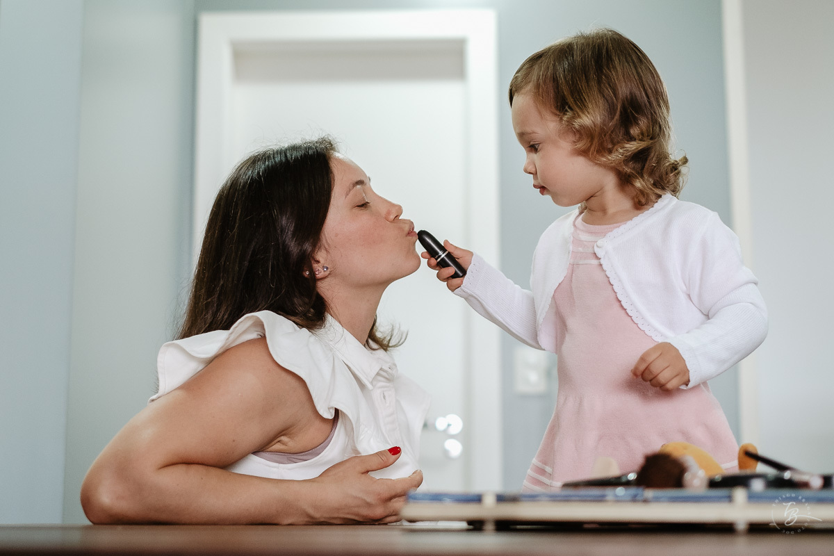 Filha pintando sua mãe. Fotografia documental de aniversário infantil em Florianópolis/Sc por Thiago Braga.
