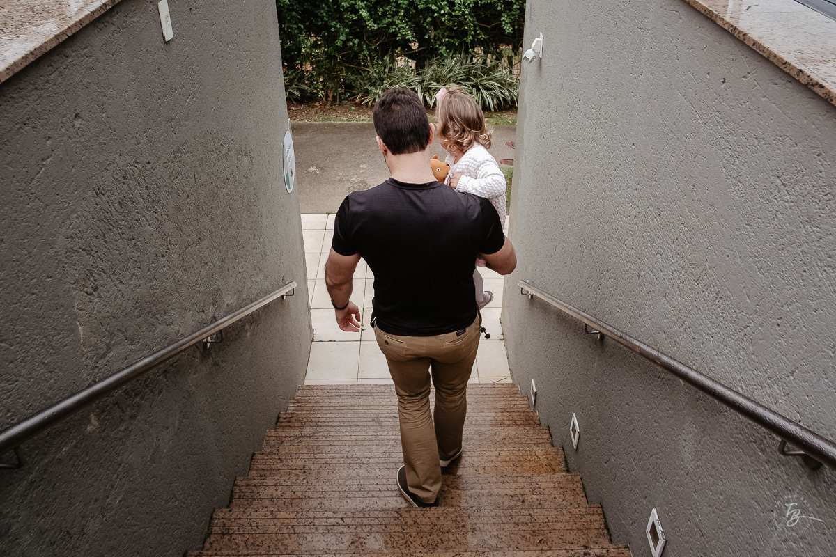 pai levando sua filha para a festa. Fotografia documental de aniversário infantil em Florianópolis/Sc por Thiago Braga.