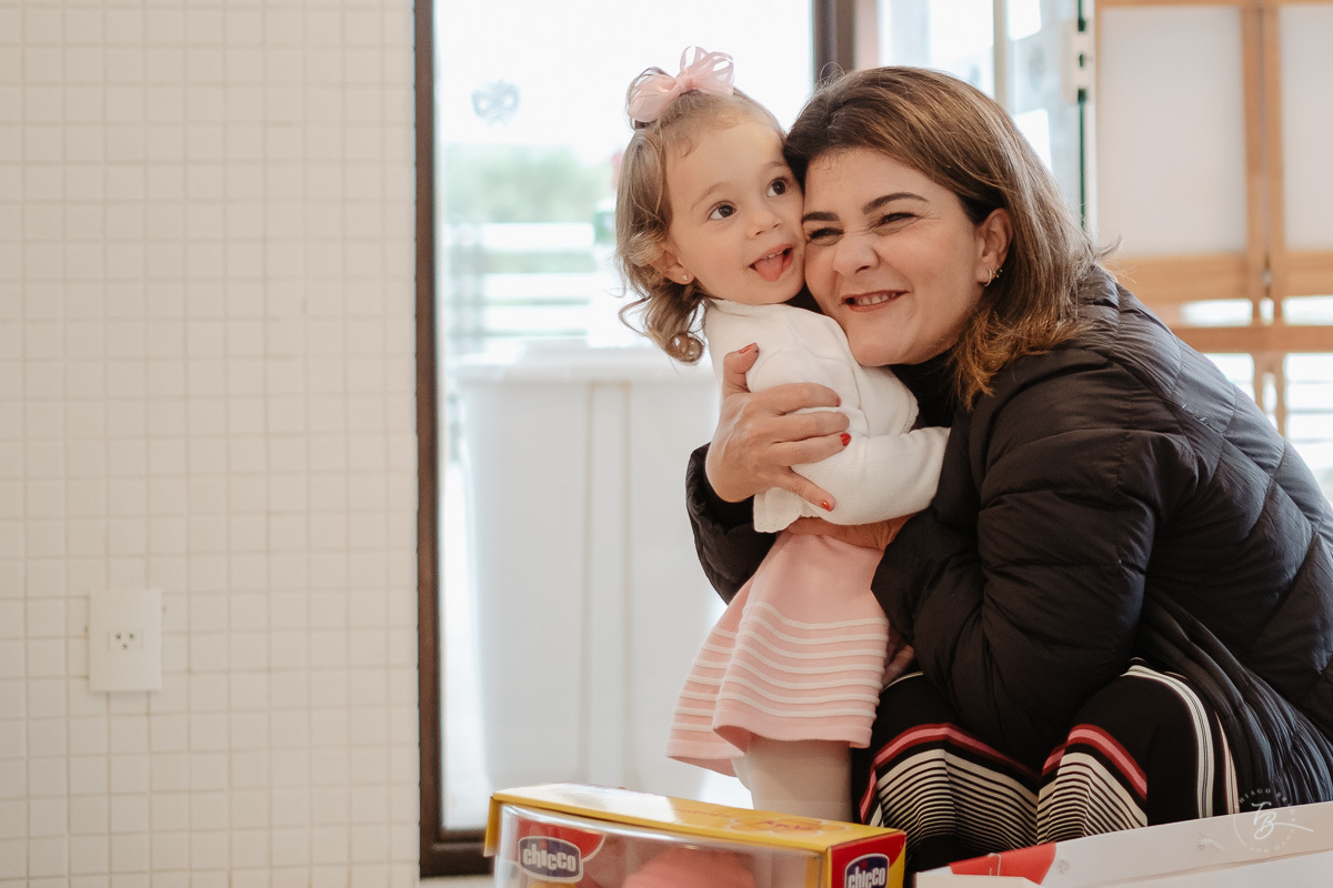 Abraço da madrinha. Fotografia documental de aniversário infantil em Florianópolis/Sc por Thiago Braga.