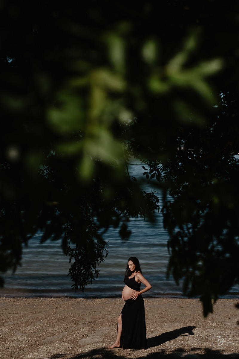 Emoldurada em meio a natureza. Ensaio gestante por Thiago Braga Fotografia. Sessão lifestyle na praia do Bom Abrigo, em Florianópolis-SC. 