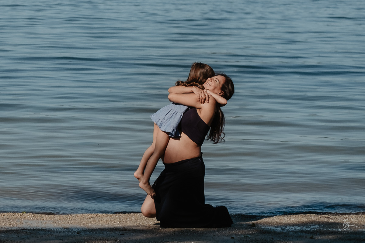 Abraço todo especial entre mãe e filha. Ensaio gestante por Thiago Braga Fotografia. Sessão lifestyle na praia do Bom Abrigo, em Florianópolis-SC. 