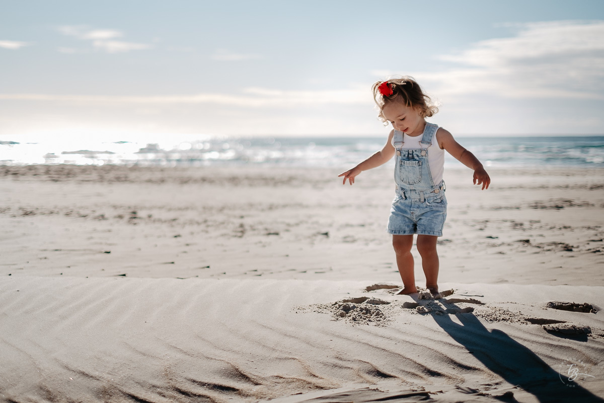 Criança brincando na areai da praia do Santinho. Ensaio lifestyle família, na praia do Santinho em Florianópolis, por Thiago Braga Fotografia. 