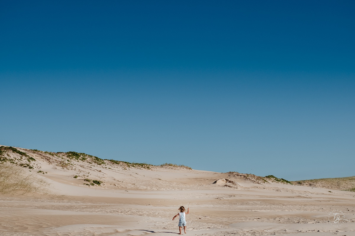 Criança livre, na praia. Ensaio lifestyle família, na praia do Santinho em Florianópolis, por Thiago Braga Fotografia. 