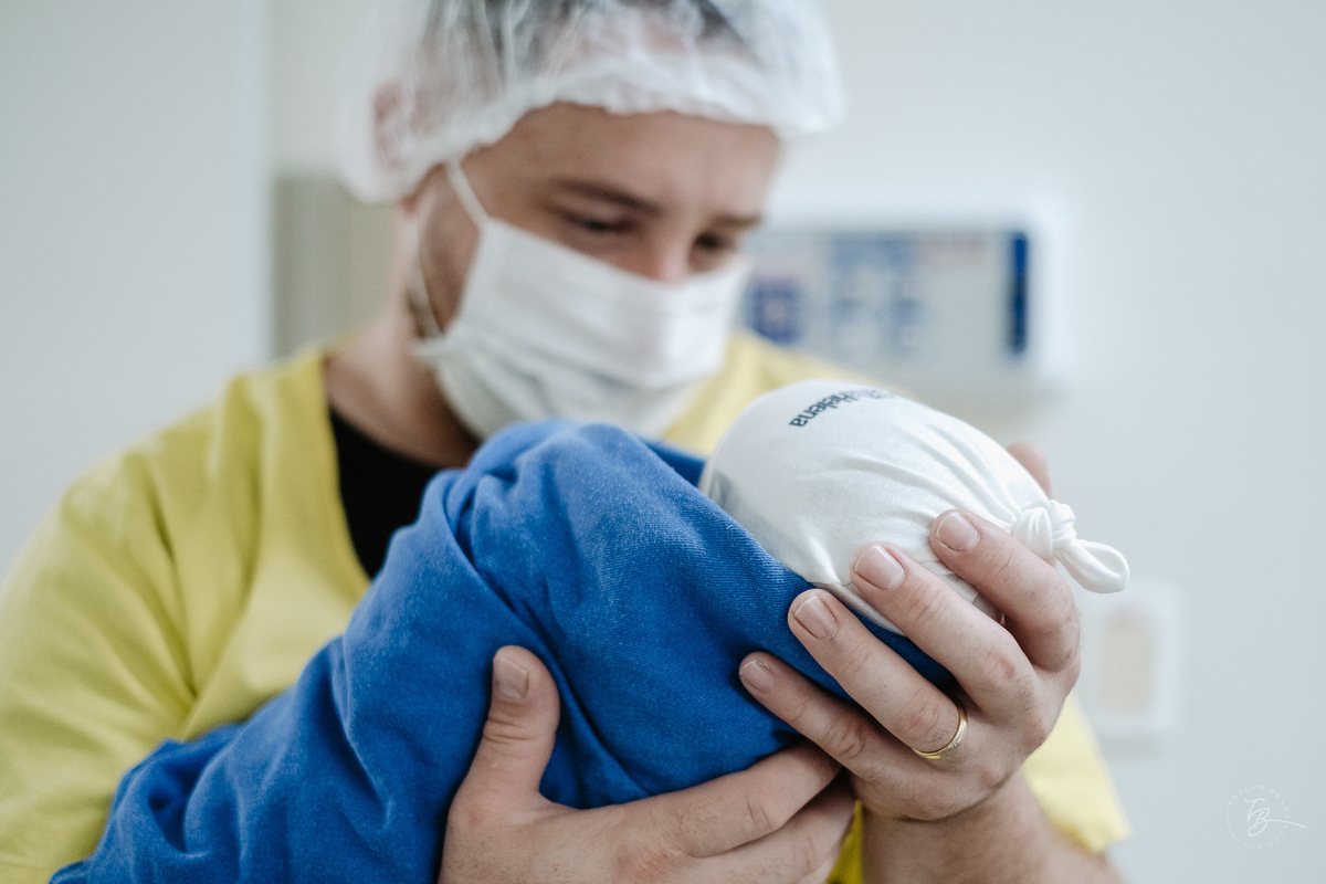 Pai no nascimento. Nascimento do Heitor. Parto Cesárea. Fotografia documental de parto por Thiago Braga.