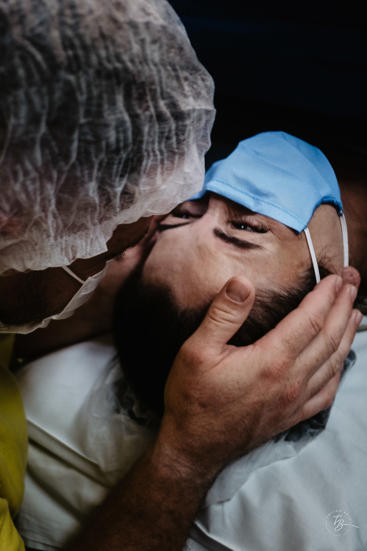 Carinho do papai na mamãe. Nascimento do Heitor. Parto Cesárea. Fotografia documental de parto por Thiago Braga.
