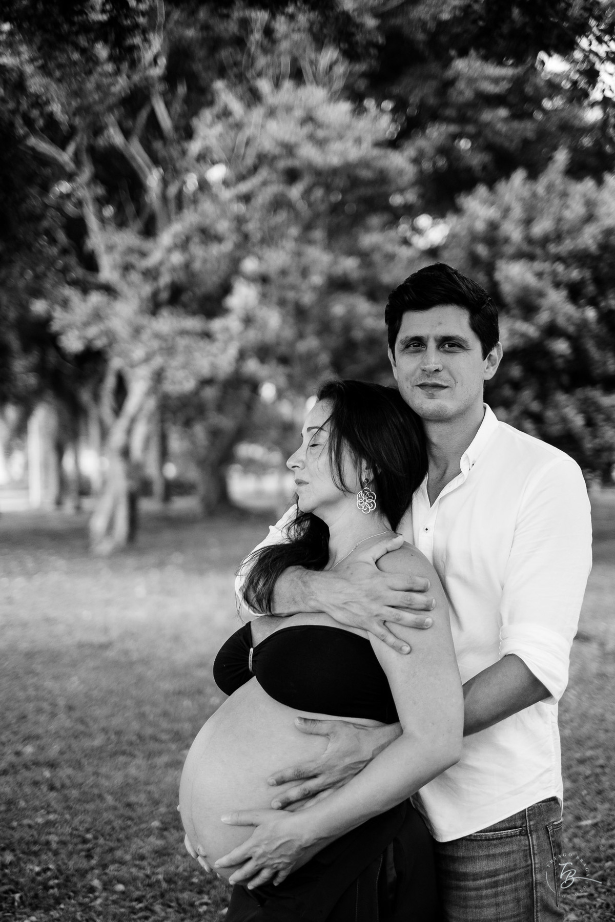 Abraço de casal aguardando gêmeos. Sessão gestante na rótula do Córrego Grande em Florianópolis - SC por Thiago Braga fotografia