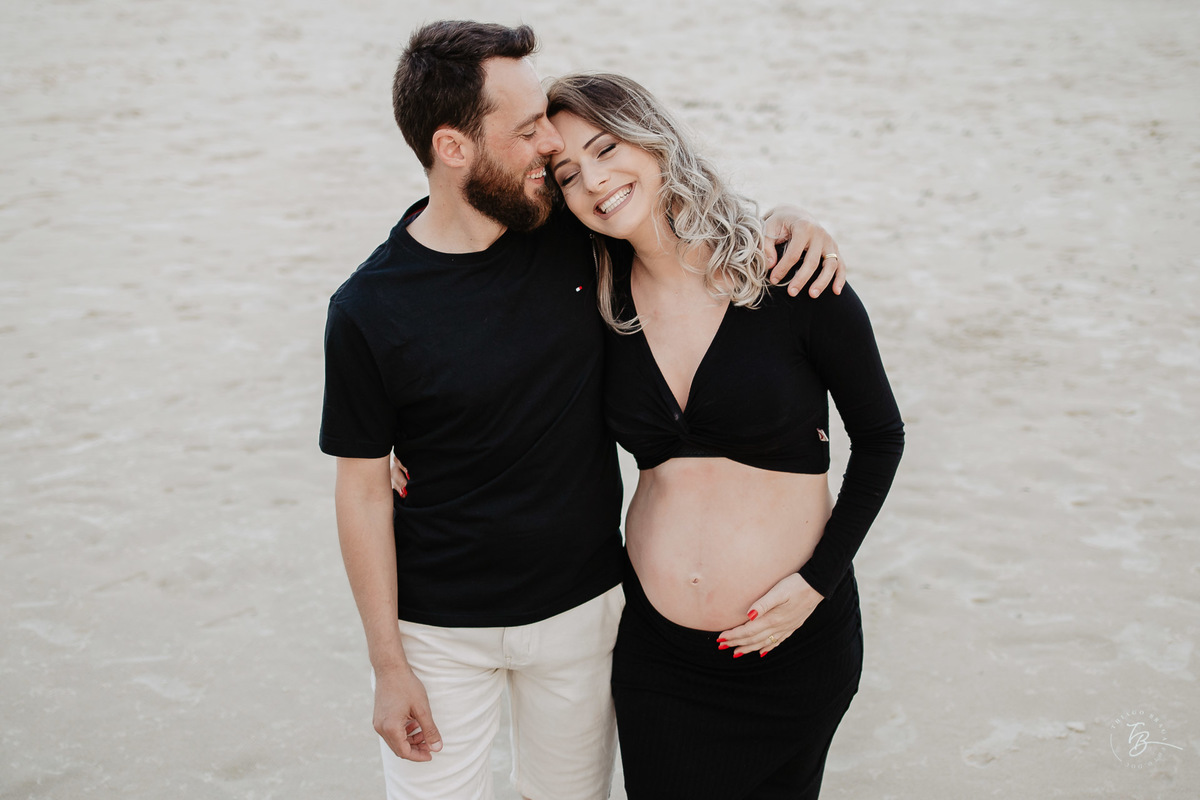 Casal esperando bebê, abraçados e felizes na praia de Mariscal. sessão gestante em Bombinhas, por Thiago Braga fotografia. 
