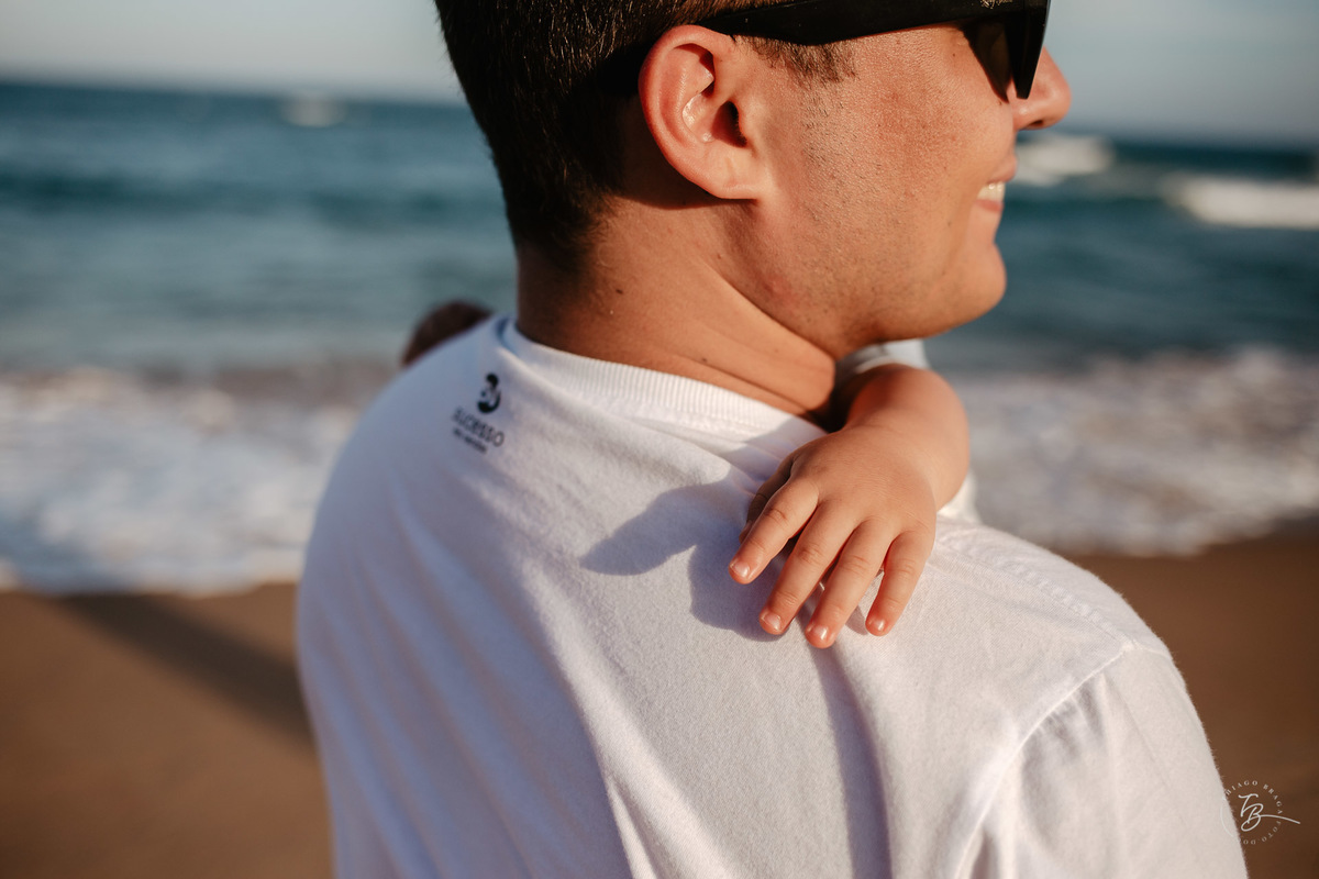 Filho com seu pai abraçados. Ensaio lifestyle. Fotos de Família em Garopaba - SC. Por Thiago Braga