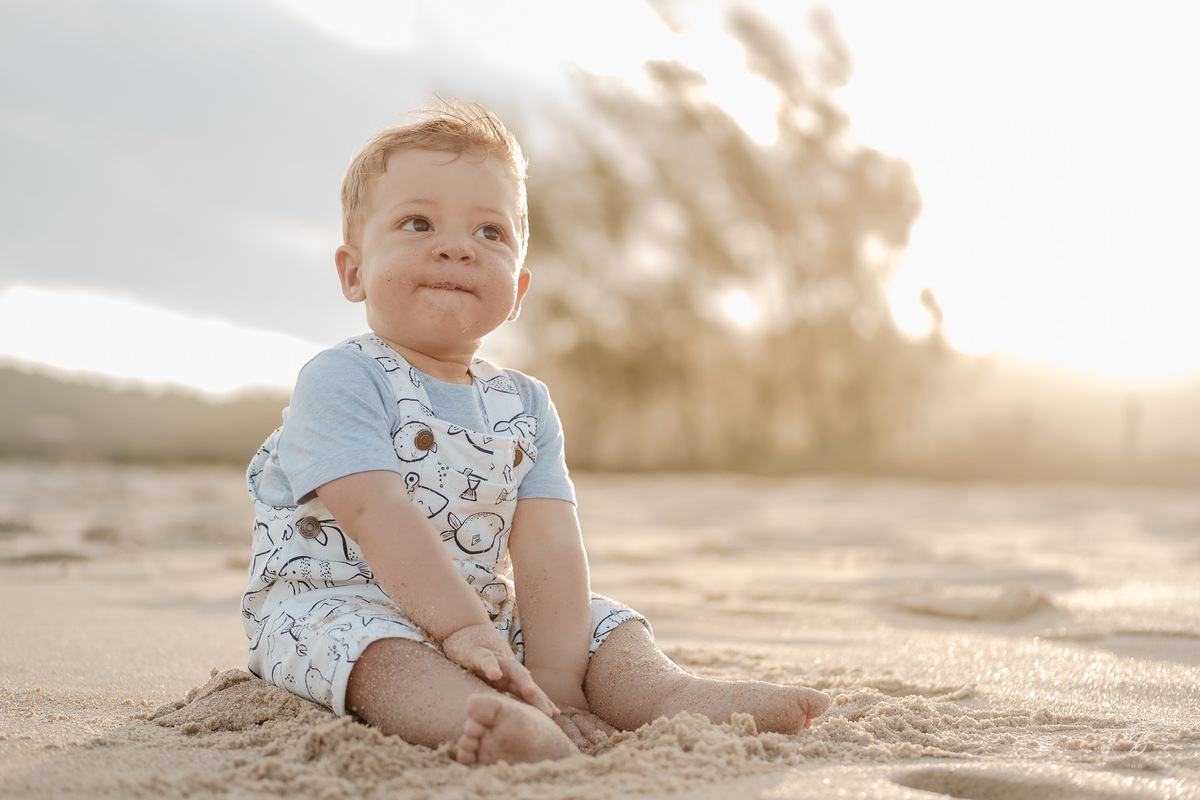 Bebê com sorriso na praia. Ensaio lifestyle. Fotos de Família em Garopaba - SC. Por Thiago Braga