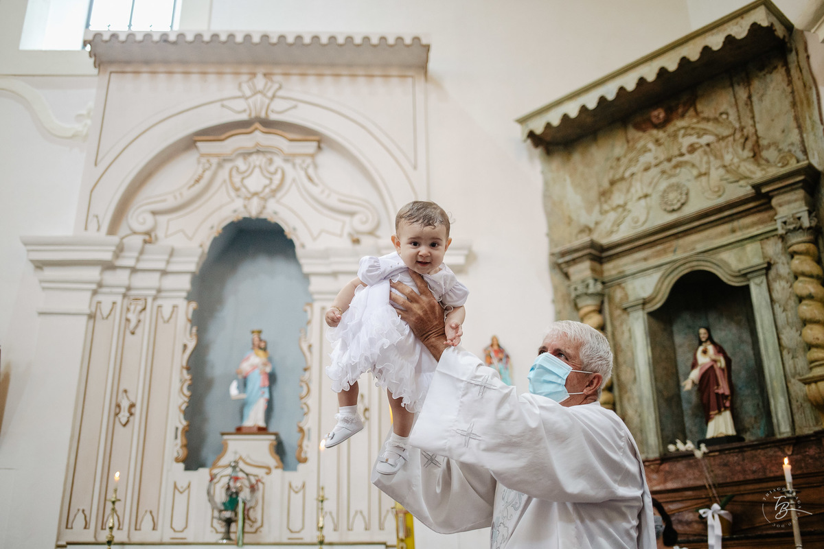 Padre abençoando. O dia do batizado da Lara, na Igreja santuário da Imaculada conceição, na Lagoa em Florianópolis. - SC, por Thiago Braga Fotografia.