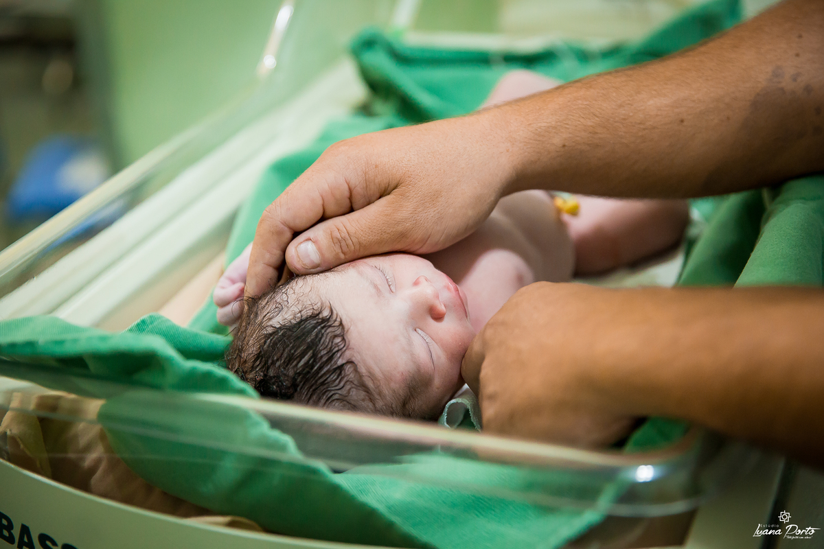 Papai fazendo carinho no bebe recém nascido