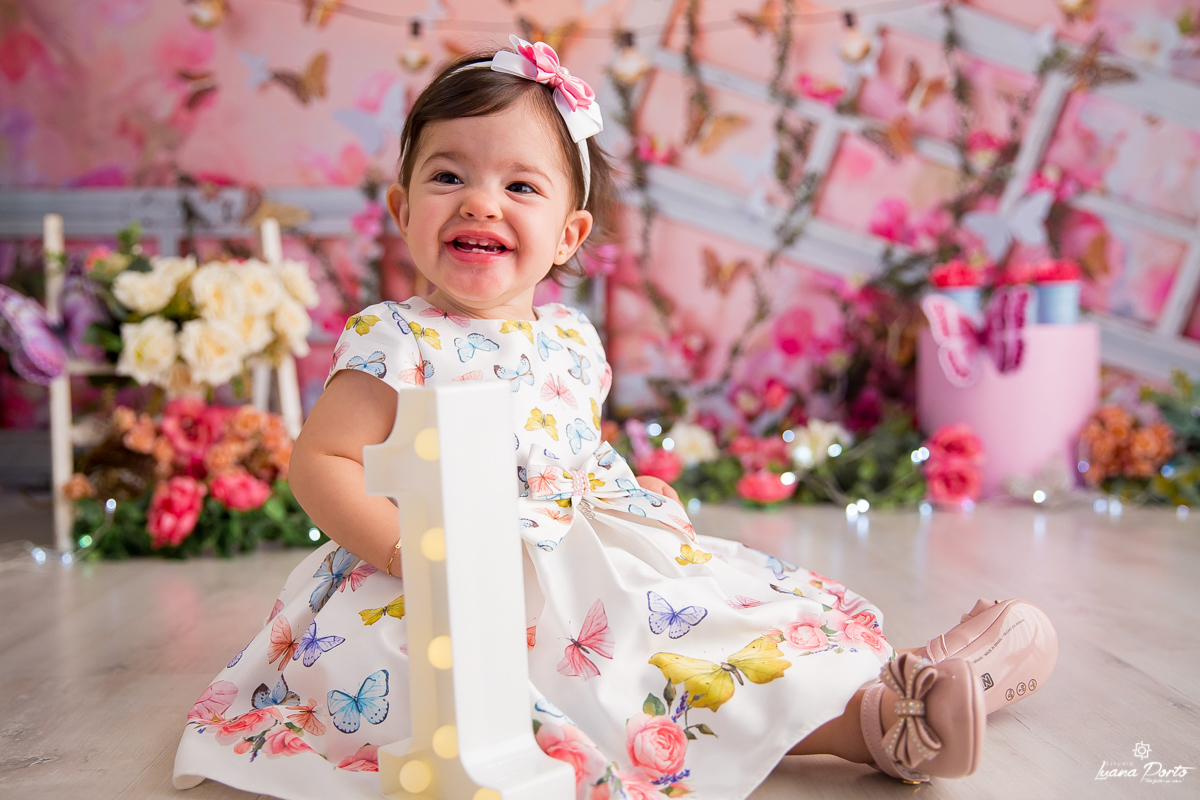 Fotografia de menina cheia de sorrisos no jardim