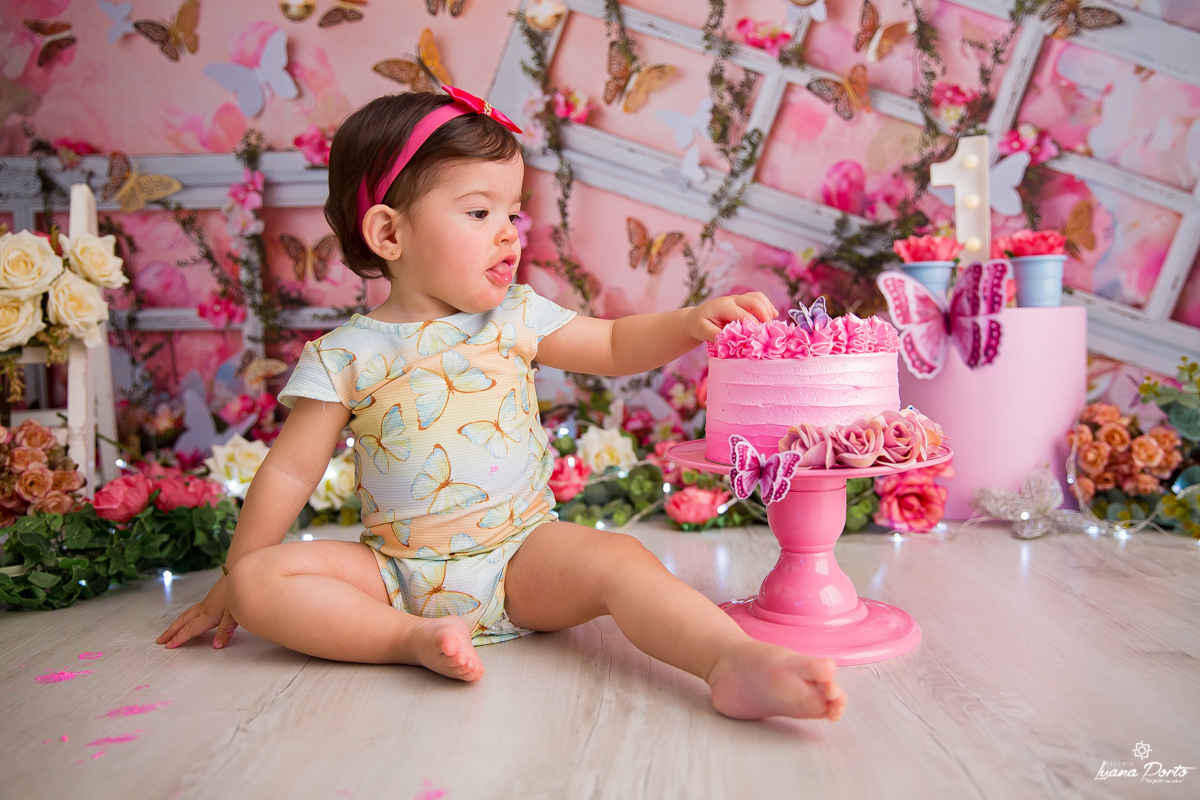 Foto de bebê menina tocando pela primeira vez no bolo do seu smash the cake