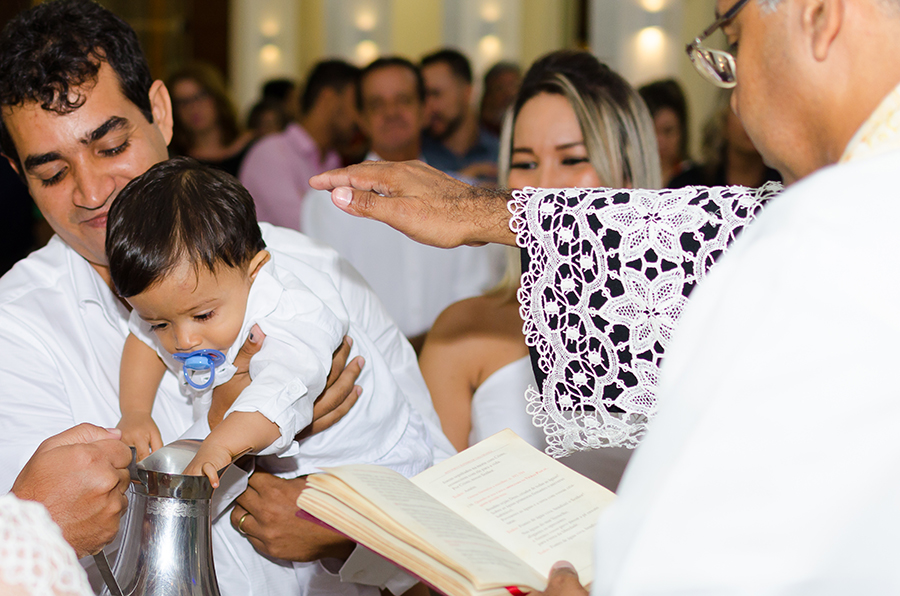 menino brincando com jarra batismo