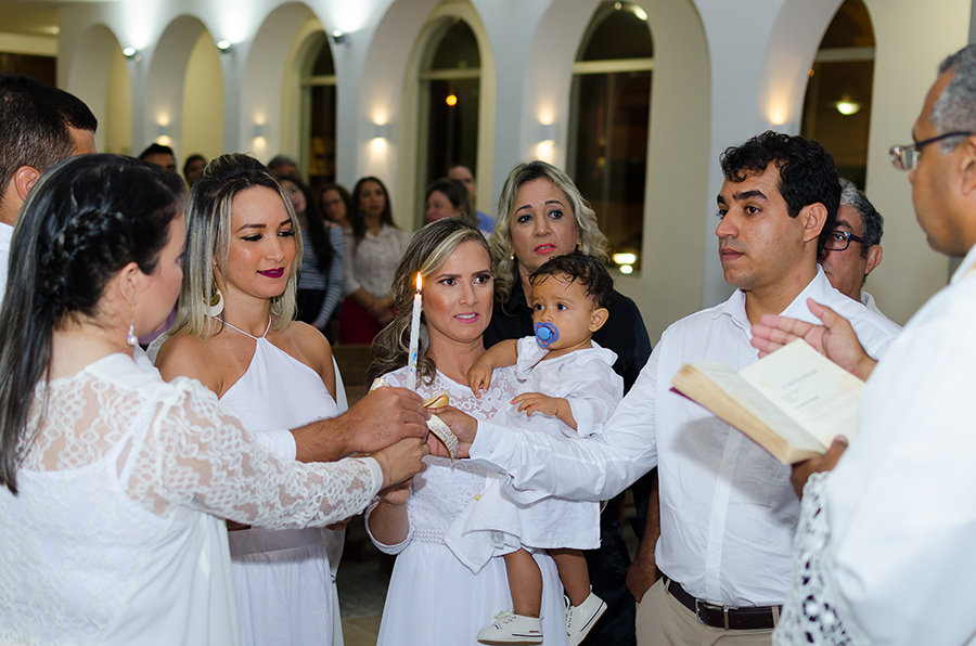 família segurando vela batismo