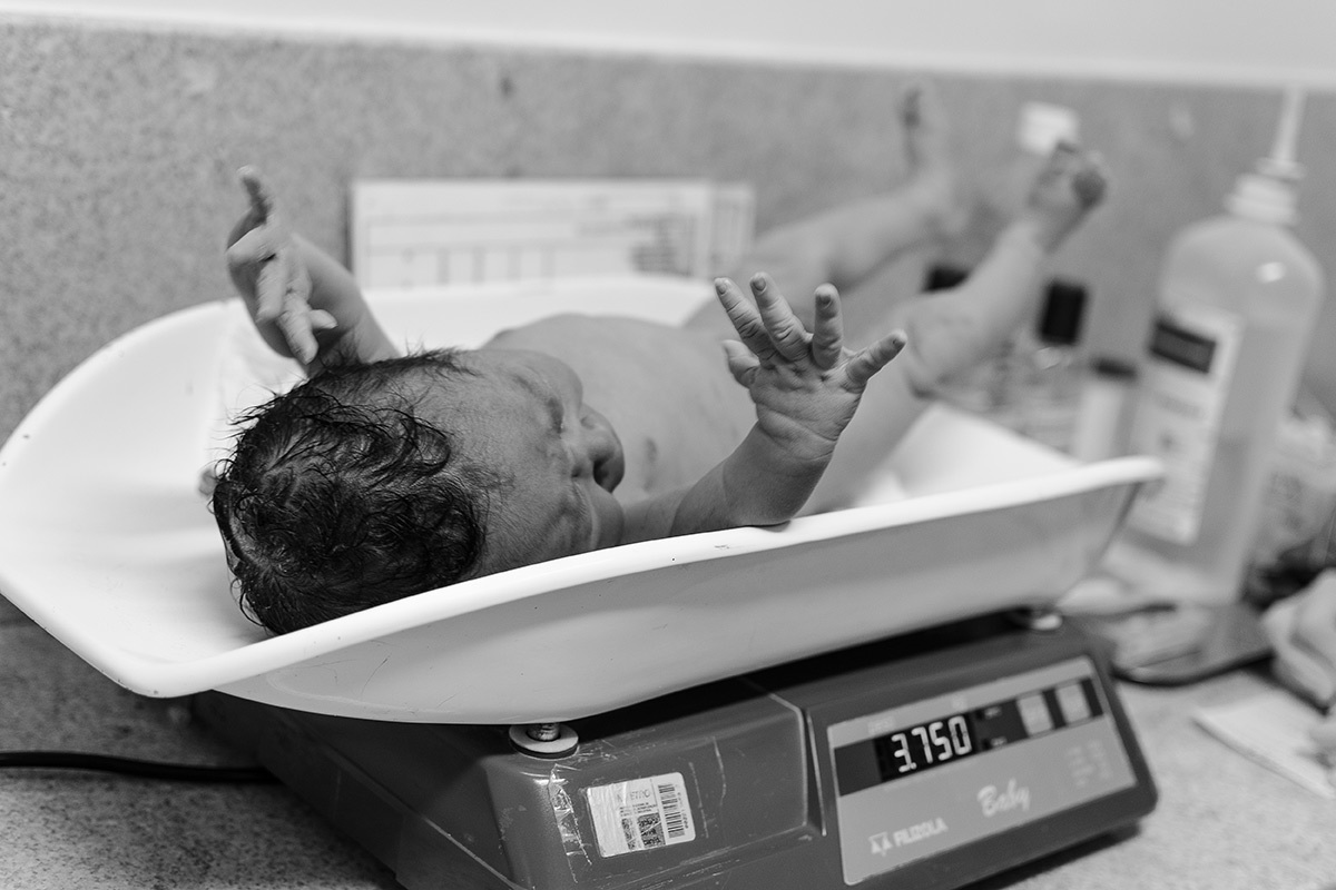 bebê sendo pesado balança parto