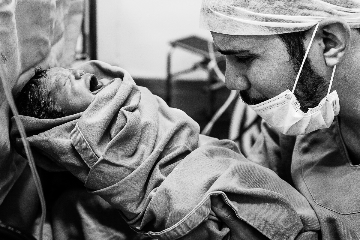 pai ora emocionado com filho no colo