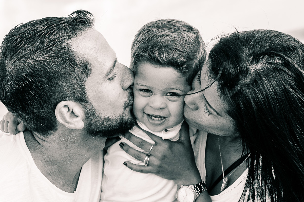 pais beijando filho na bochecha