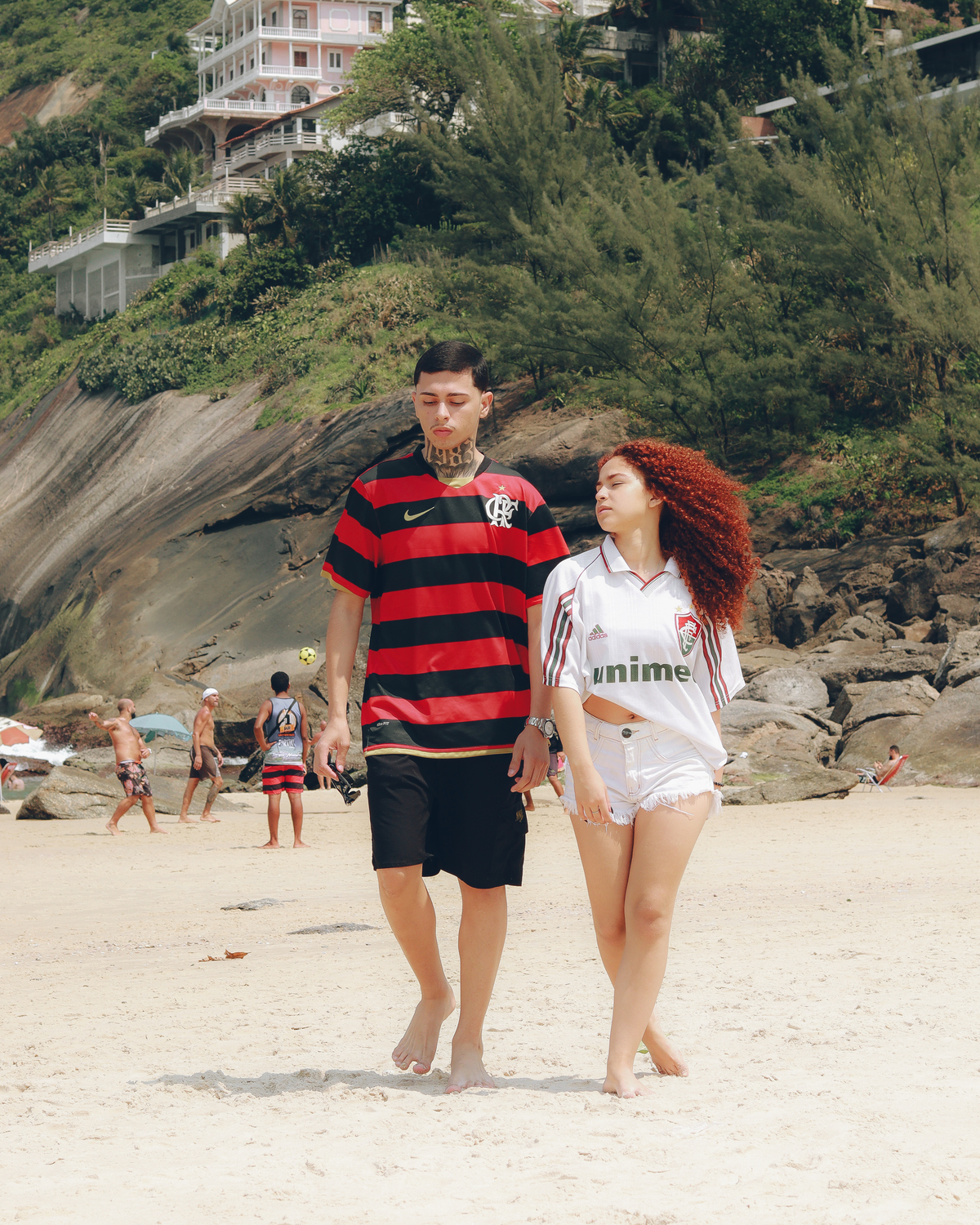 Casal andando na praia de 
Itacoatiara