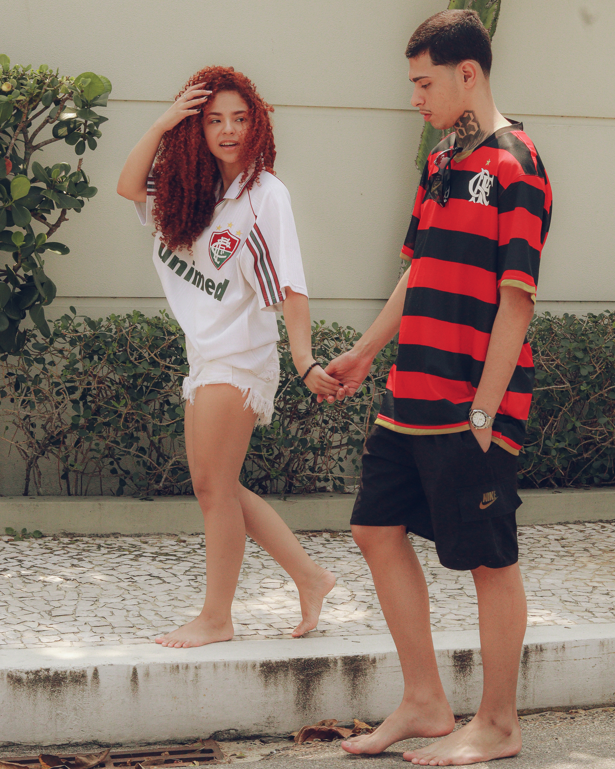 Casal com camisa de time andando na rua